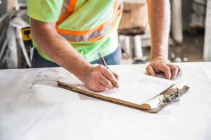 Man writing on a paper on a clipboard