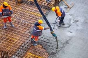 3 construction workers pouring concrete