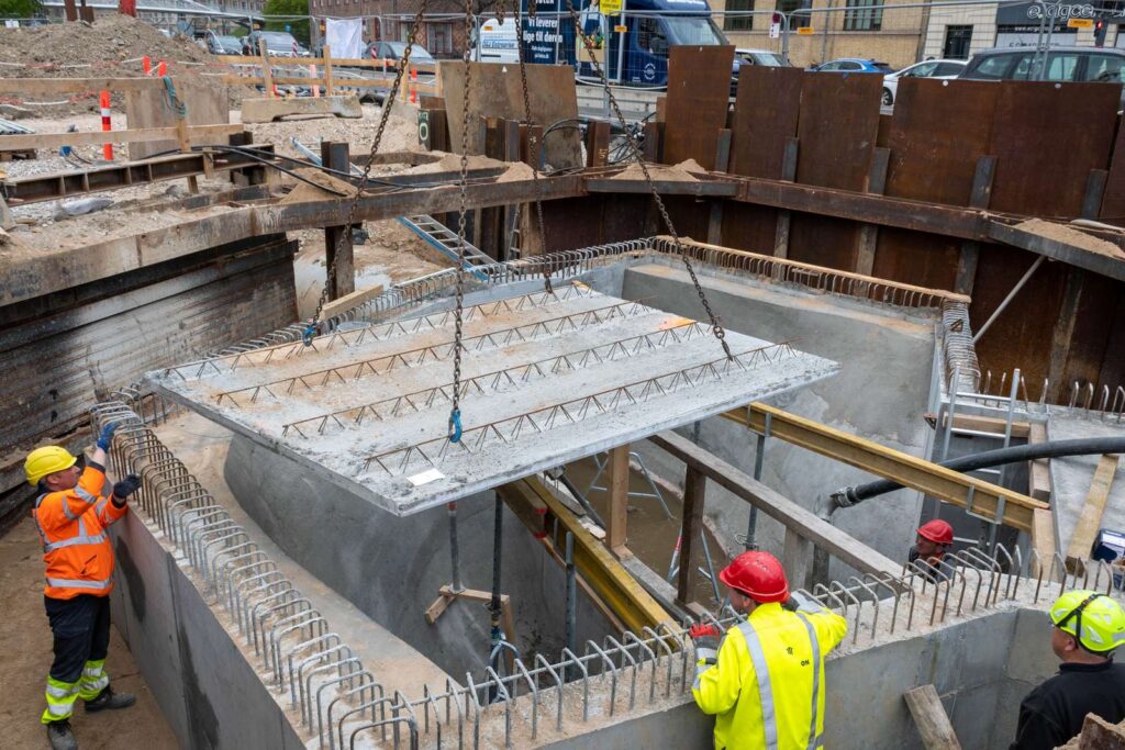 A large concrete square being placed in construction site