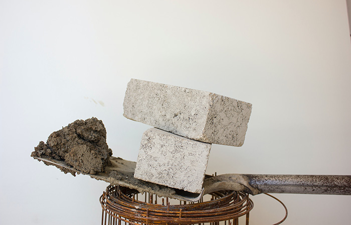 Shovel with wet concrete and bricks.