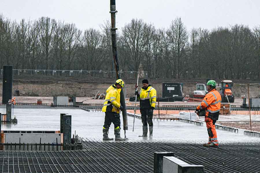 3 construction workers pouring concrete